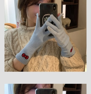 Detail of light blue knit gloves with red bow embroidery during a mirror selfie