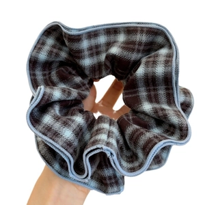 Plaid checkered hair scrunchie in blue and brown fabric held for size display