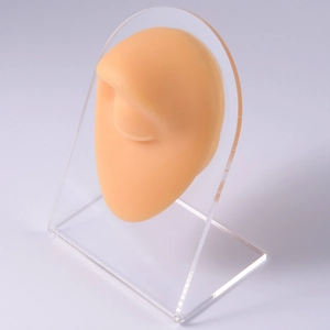 Detailed flesh-tone silicone ear model on acrylic stand for jewelry display
