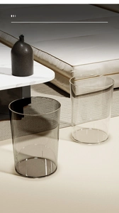 Detail of transparent and smoky grey waste bins in a modern living room setting