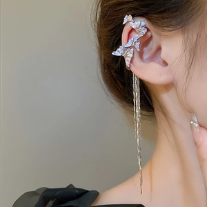 Detailed view of silver butterfly tassel earrings worn by a model in a side profile