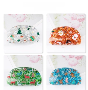 Detailed view of four acrylic Christmas hair claws with glitter and festive patterns