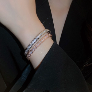 Close-up of elegant zircon paved bangles in silver and rose gold on a woman wrist