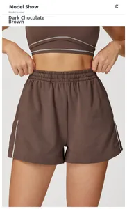 Dettaglio dei pantaloncini sportivi marrone cioccolato con strisce bianche e vita alta