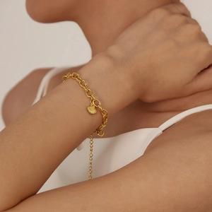 Golden chunky chain bracelet with a detailed seashell charm and adjustable extension