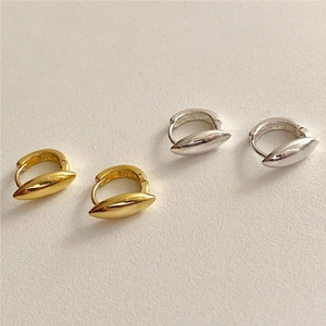 Detail view of gold and silver olive-shaped 925 sterling silver huggie earrings
