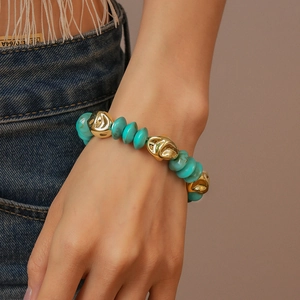 Close-up of turquoise beads and golden irregular metal accents on a beaded bracelet