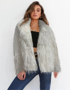 Detailed texture of white faux fur coat showing long plush fabric and shaggy finish