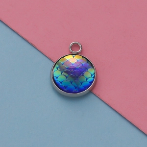 Macrodetail van een 12mm zilveren ronde hars hanger met blauw-paarse vissen schubben