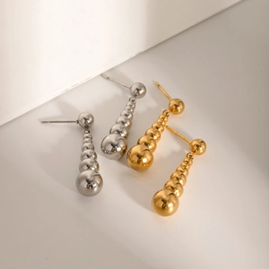 Detail view of gold and silver 18k stainless steel earrings with gradient pearl pendants