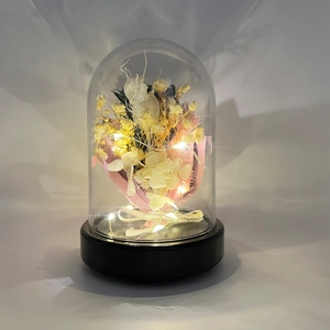 Macro detail of eternal flower arrangement with LED lights and a clear display dome