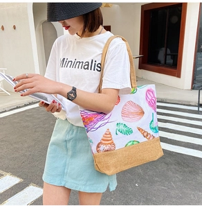 Canvas tote bag with colorful shell patterns and brown base shown in a street setting