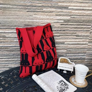 Close-up of red and black knitted tote bag featuring a cute rabbit pattern and wide strap