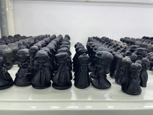 Detailed close-up of matte black obsidian puppy figurines neatly arranged on shelves