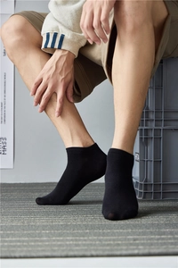 Detailed view of mid-cut black cotton athletic socks worn for men with comfortable fit