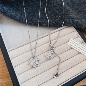 Detail showing silver horse pendant with Lucky engraving and adjustable floral chain