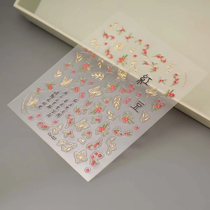 Macro shot of 3D gold-edged cherry and butterfly nail stickers with Chinese calligraphy