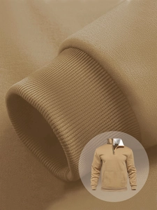 Detailed close-up of camel color knit hoodie cuff and high-density ribbed texture