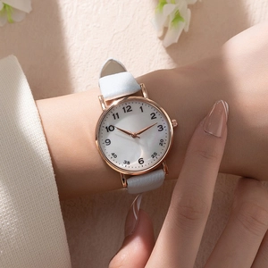 Elegant women's quartz watch with rose gold case and white leather strap worn on wrist