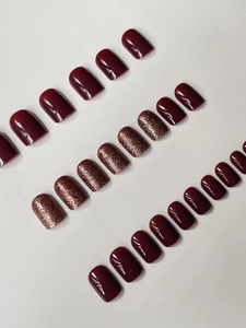 Macro detail of red glossy and rose gold glitter square press-on nails set in array