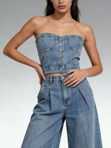Détail du haut tube en jean ajusté avec boutons métalliques et pantalon en jean large