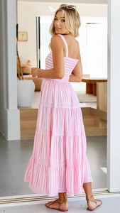 Détail d'une robe longue d'été à rayures roses et blanches avec ourlet à volants