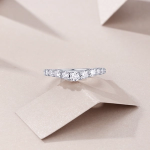 Detail view of silver eternity ring with round cut moissanite stones in a curved setting