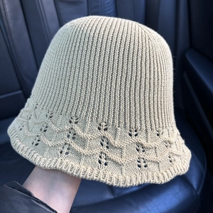 Detail of knitted bucket hat featuring a wavy lace crochet brim in beige finish