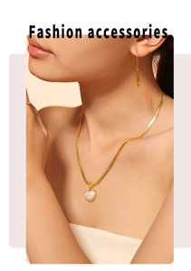 Close-up of heart-shaped shell pendant necklace and gold bar earrings on a model