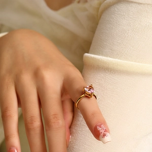 Close-up of heart-shaped pink zircon ring in 18k gold plating on a finger