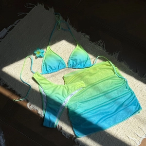 Détail d'un bikini 3 pièces dégradé vert fluo et bleu avec jupe paréo à volants