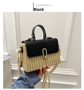 Detail of beige straw bag with black leather flap, golden twist lock and rope strap
