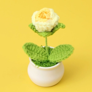 Detail of handmade crochet yellow rose in white ceramic pot for home desk decoration