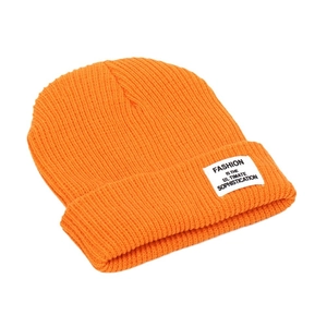 Classic orange ribbed knit beanie with fashion textile label on folded cuff in side view
