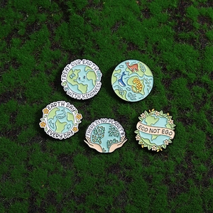 Five eco-friendly enamel pins with nature motifs on moss background for bags and clothes