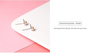 Macro detail of cloud-shaped silver earrings with natural freshwater pearls