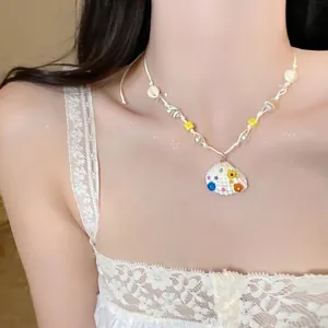 Detailed shot of starfish shell pendant necklace with colorful beads on white lace background