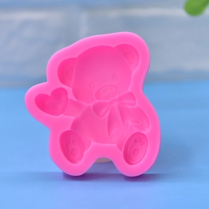 Pink silicone teddy bear mold with heart and bow details for DIY cake and soap making