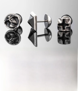 Detail view of silver titanium steel earrings with cross and portrait relief designs