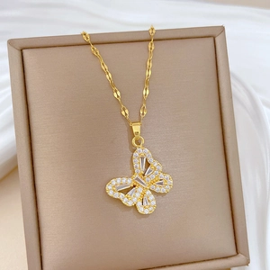 Detailed macro view of golden butterfly necklace with sparkling white zircons on soft silk