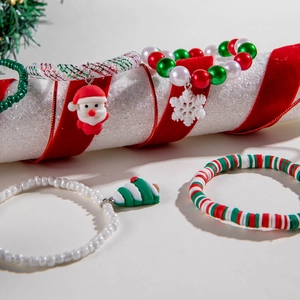 Detailed view of Christmas bracelets featuring Santa, snowflake, and tree charms on red cords