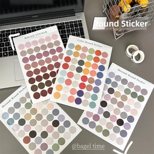 Morandi color dot stickers for journaling set on a laptop in an office desk setting