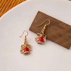 Detail of festive red and gold bell earrings with bow design on a minimalist background