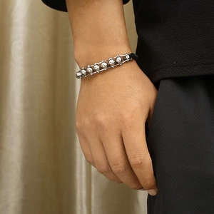 Men's braided leather bracelet featuring silver stainless steel mantra beads and gear design