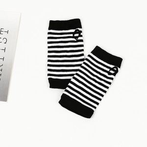 Détail de mitaines tricotées à rayures noires et blanches avec trou pour le pouce
