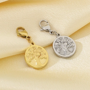 Detail of gold and silver tree of life pendants with lobster clasps on satin fabric