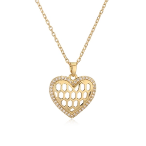 Macro detail of gold plated heart pendant with white zircon and honeycomb hollow design