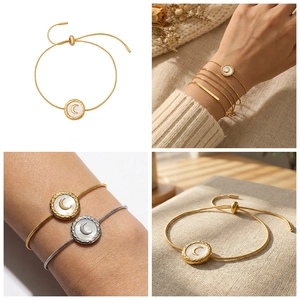 Detail of adjustable gold and silver moon bracelets with shell inlay and snake chain