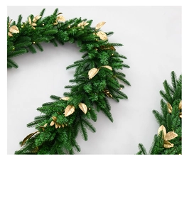 Close-up of velvet Christmas garland with matte gold leaves and warm LED light beads