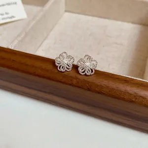 Minimalist silver hollow flower stud earrings with intricate woven texture for women